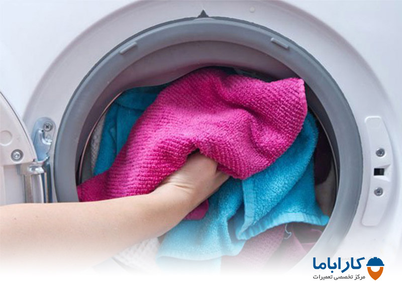 خارج کردن لباس خیس از ماشین لباسشویی برای از بین بردن کپک